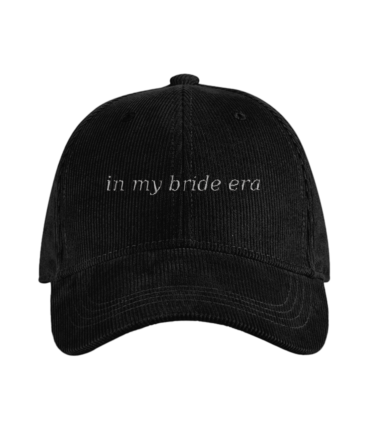 Black cap with 'in my bride era' text on a white background