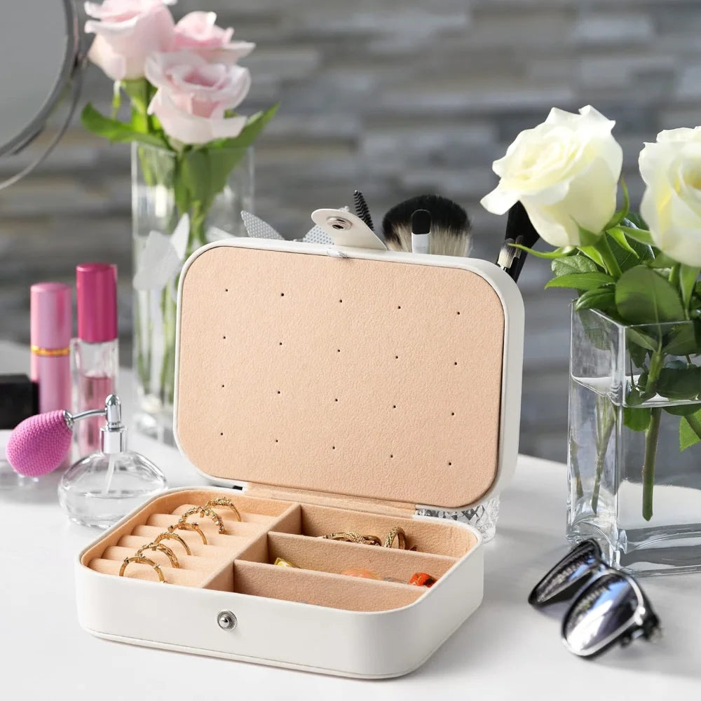 Jewelry box with jewelry on a table with flowers and makeup items in the background