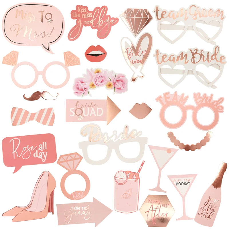 Collection of pink and rose gold party props including glasses, signs, and accessories on a white background.