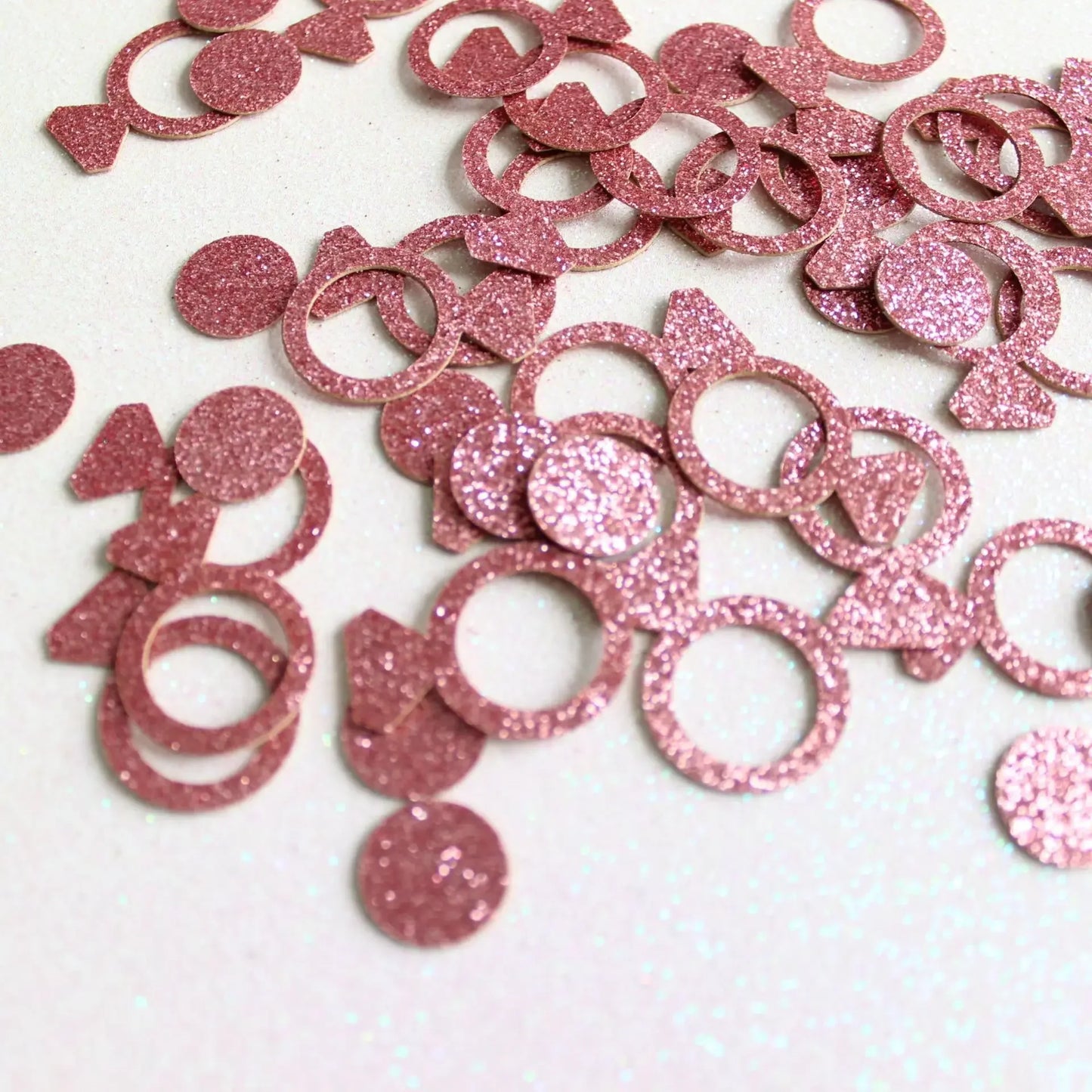 Pink glittery  engagement ring party confetti on a white background