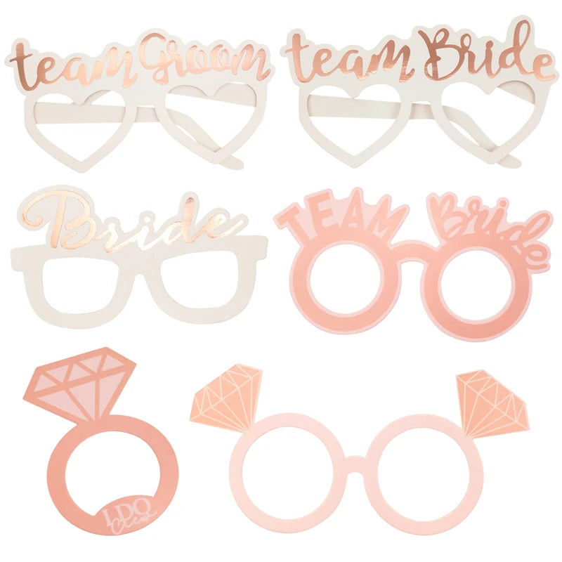 Decorative photo prop glasses with 'Team Bride' and heart designs on a white background - The Hen Planner