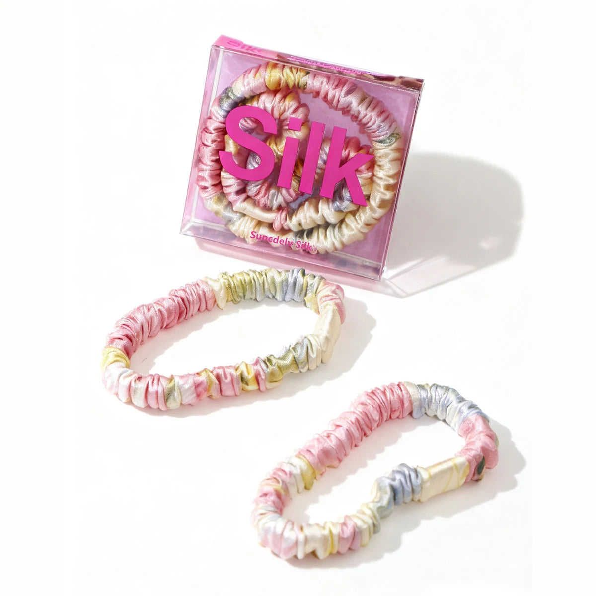 Colorful hair ties in a pink box labeled 'Silk' on a white background