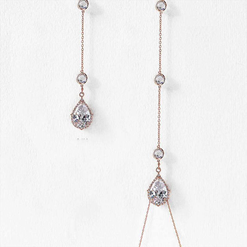 Rose gold necklace with teardrop-shaped crystals on a white background