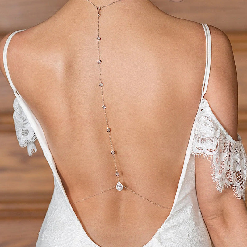 White lace lingerie with a delicate chain detail on a neutral background