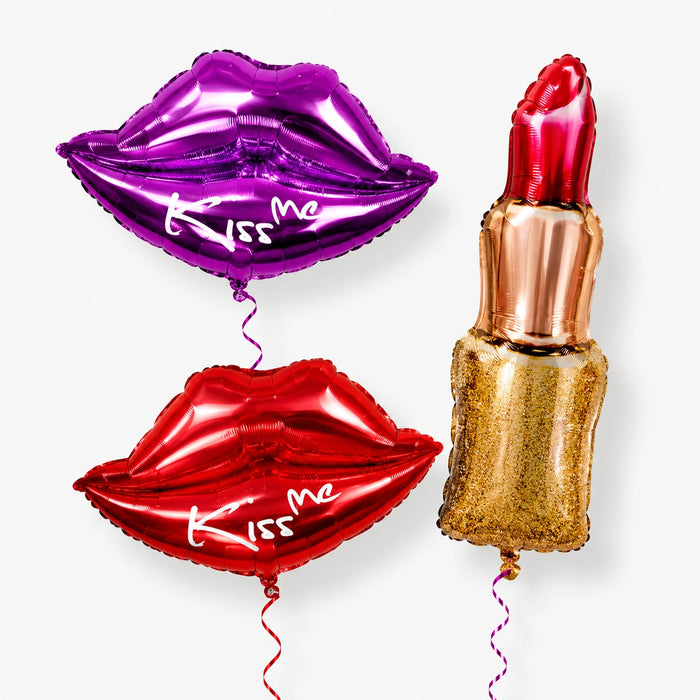 Three oversize balloons: red lips with 'Kiss me', purple lips with 'Kiss me', and lipstick.