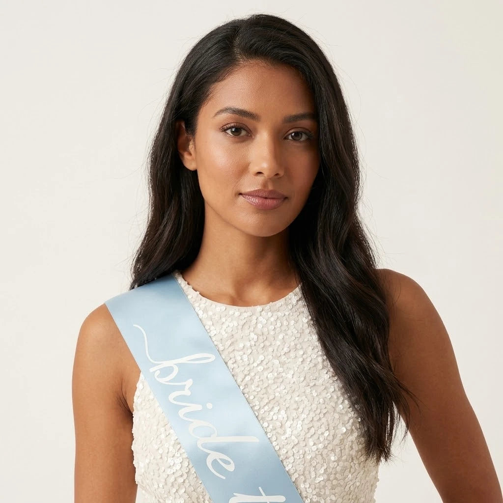 Woman wearing a 'bride to be' sash on a plain background