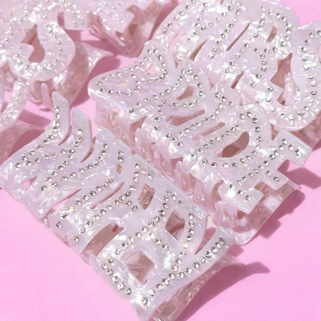 Decorative white rhinestone trim on a pink background