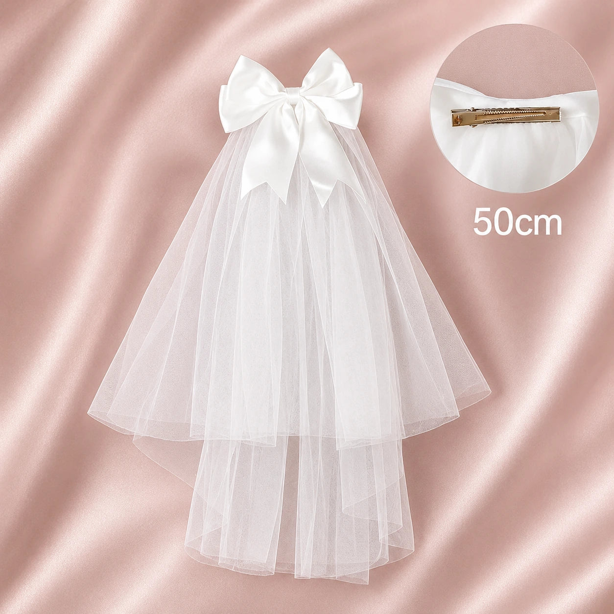 White tulle veil with a large bow on a pink satin background