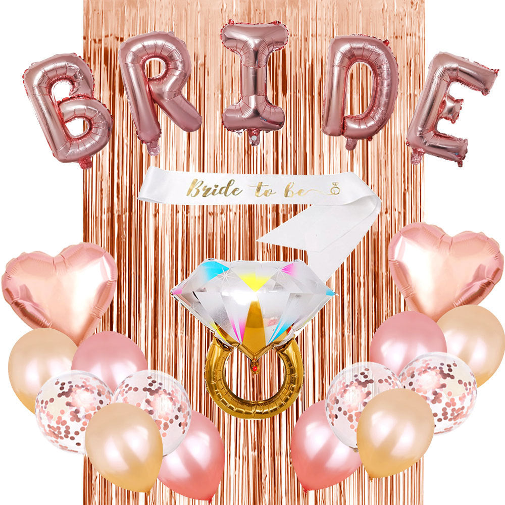 Rose gold balloons spelling 'BRIDE' with a diamond ring balloon and heart-shaped balloons against a rose gold tinsel curtain.