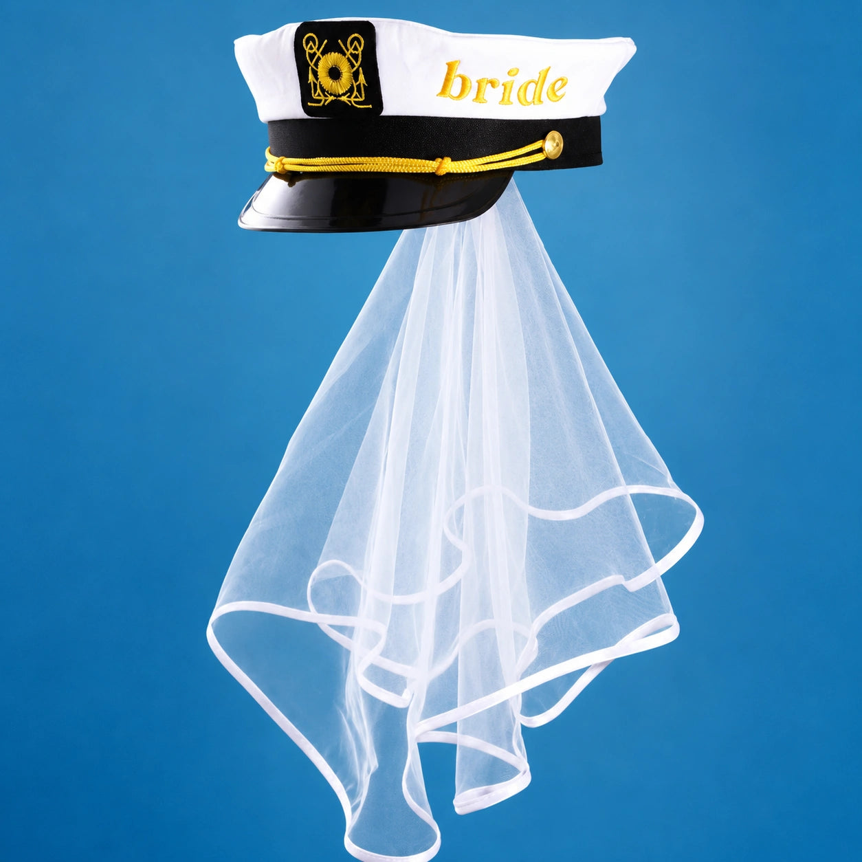 A bridal costume accessory set featuring a white and black captain-style hat with gold trim, a black band with a gold medallion, and a long flowing white tulle veil, shown against a solid blue background.