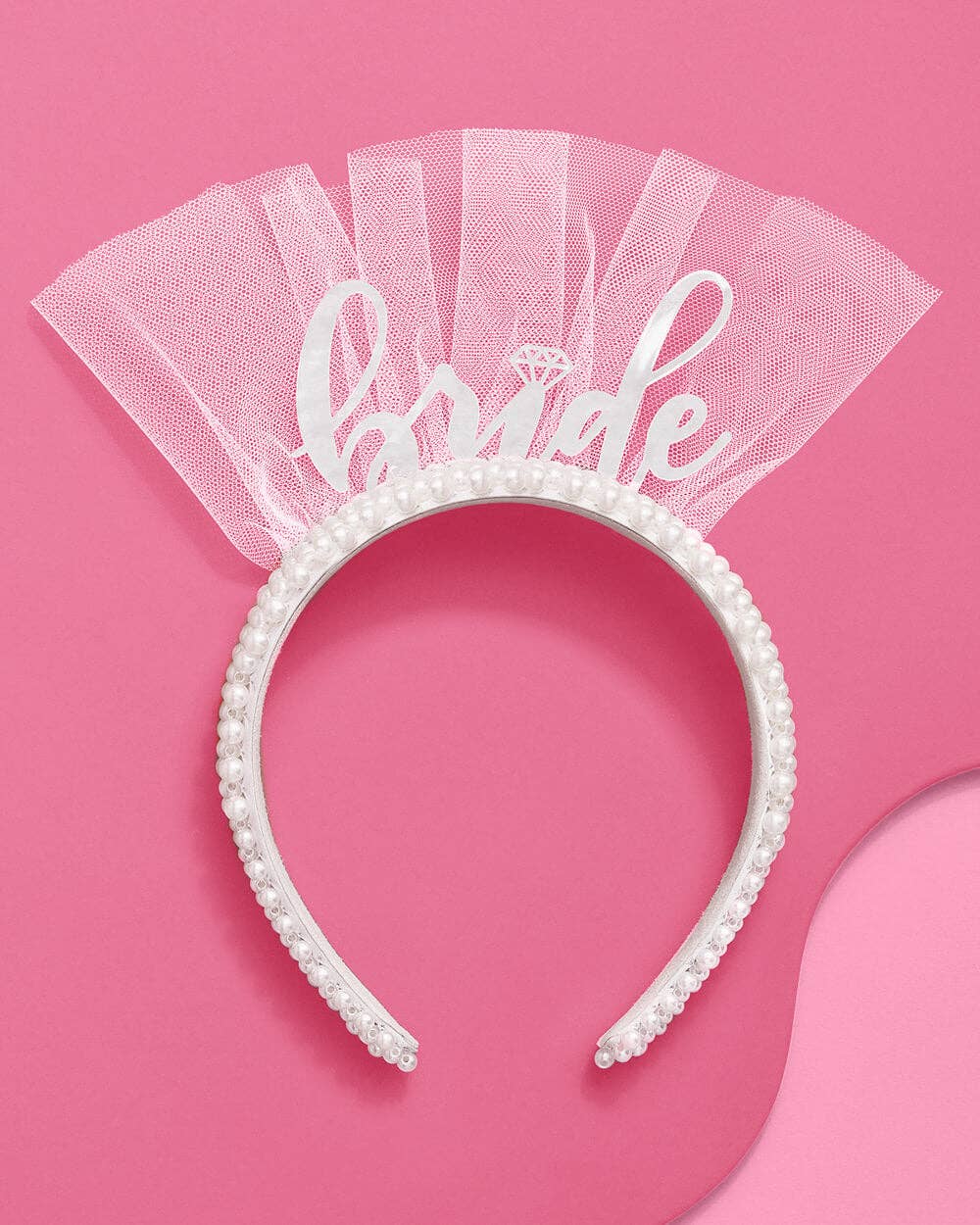 White 'bride' headband with pearls on a pink background