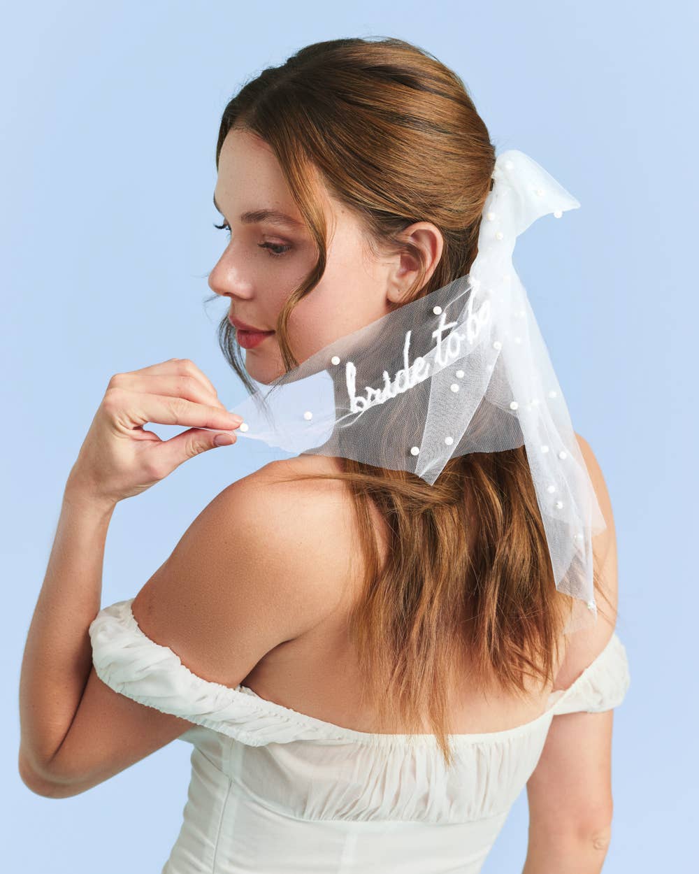 Bride wearing white bride to be pearl hair bow for bachelorette party or bridal shower