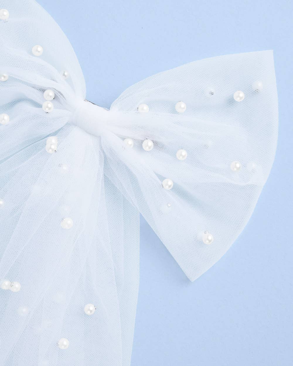 Close-up of white tulle bride to be hair bow with pearl embellishments