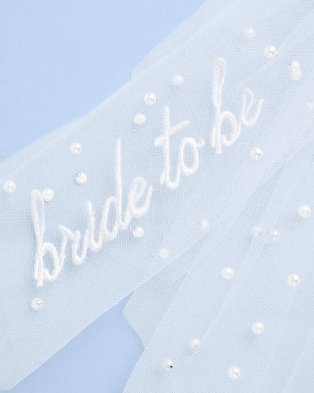 Close-up of bride to be embroidery on white tulle hair bow