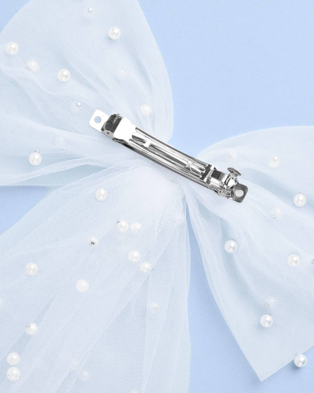Close-up of silver metal clip on white bride to be pearl hair bow