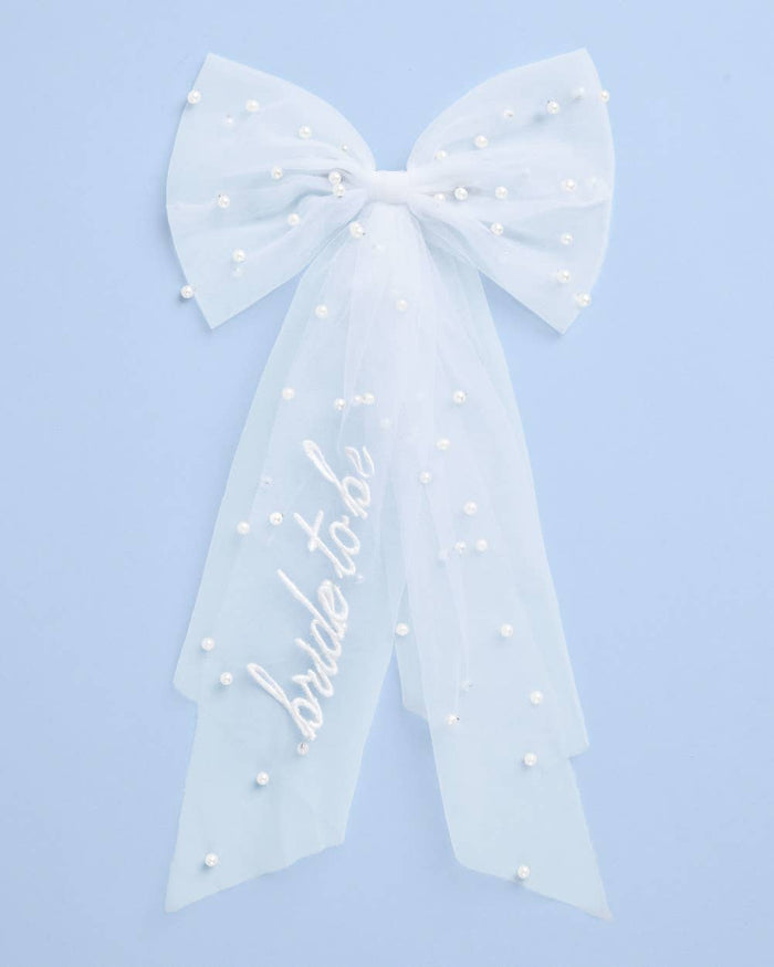 White bride to be pearl hair bow with tulle tails on blue background
