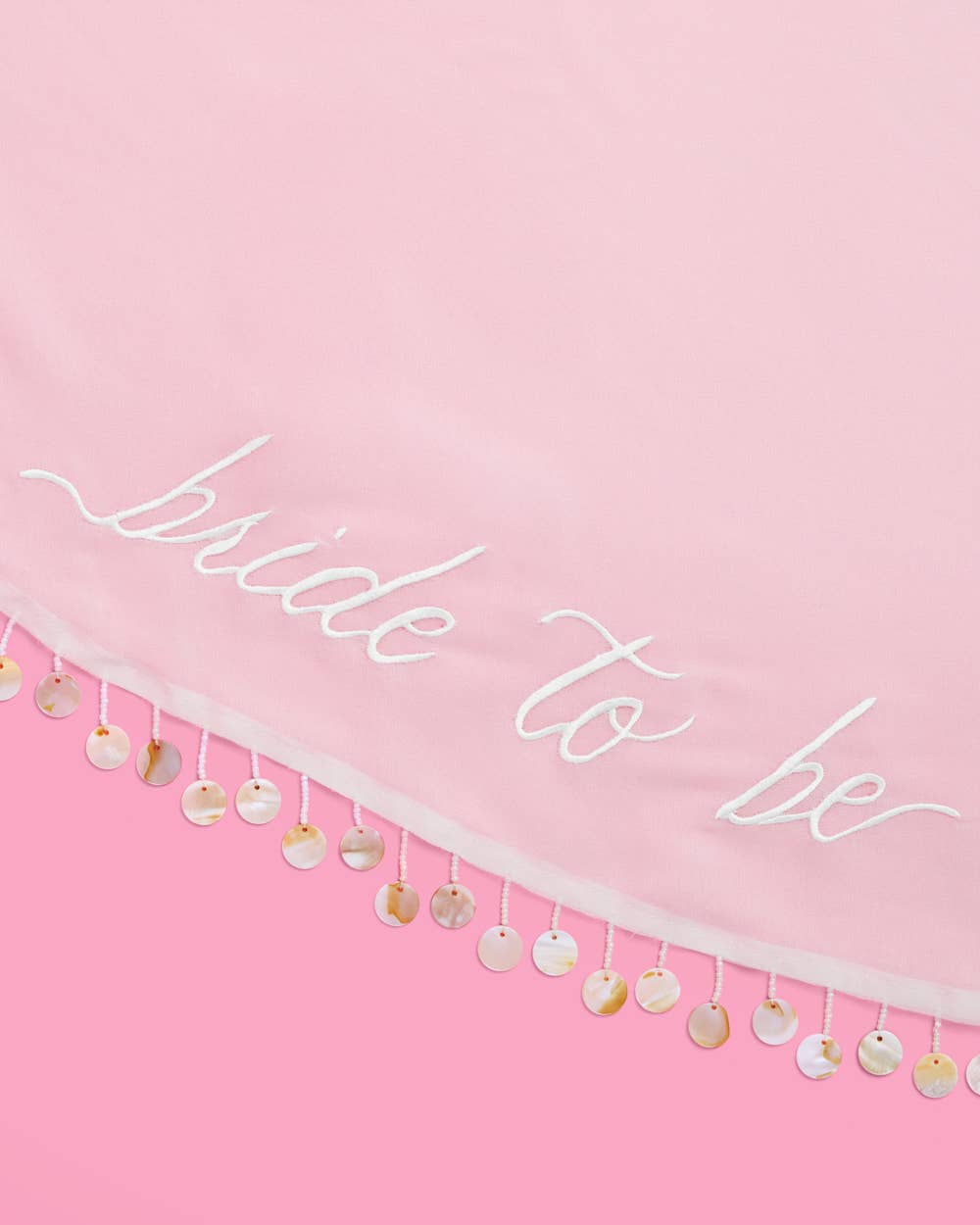 Close-up of bride to be embroidered white sarong with pearl trim