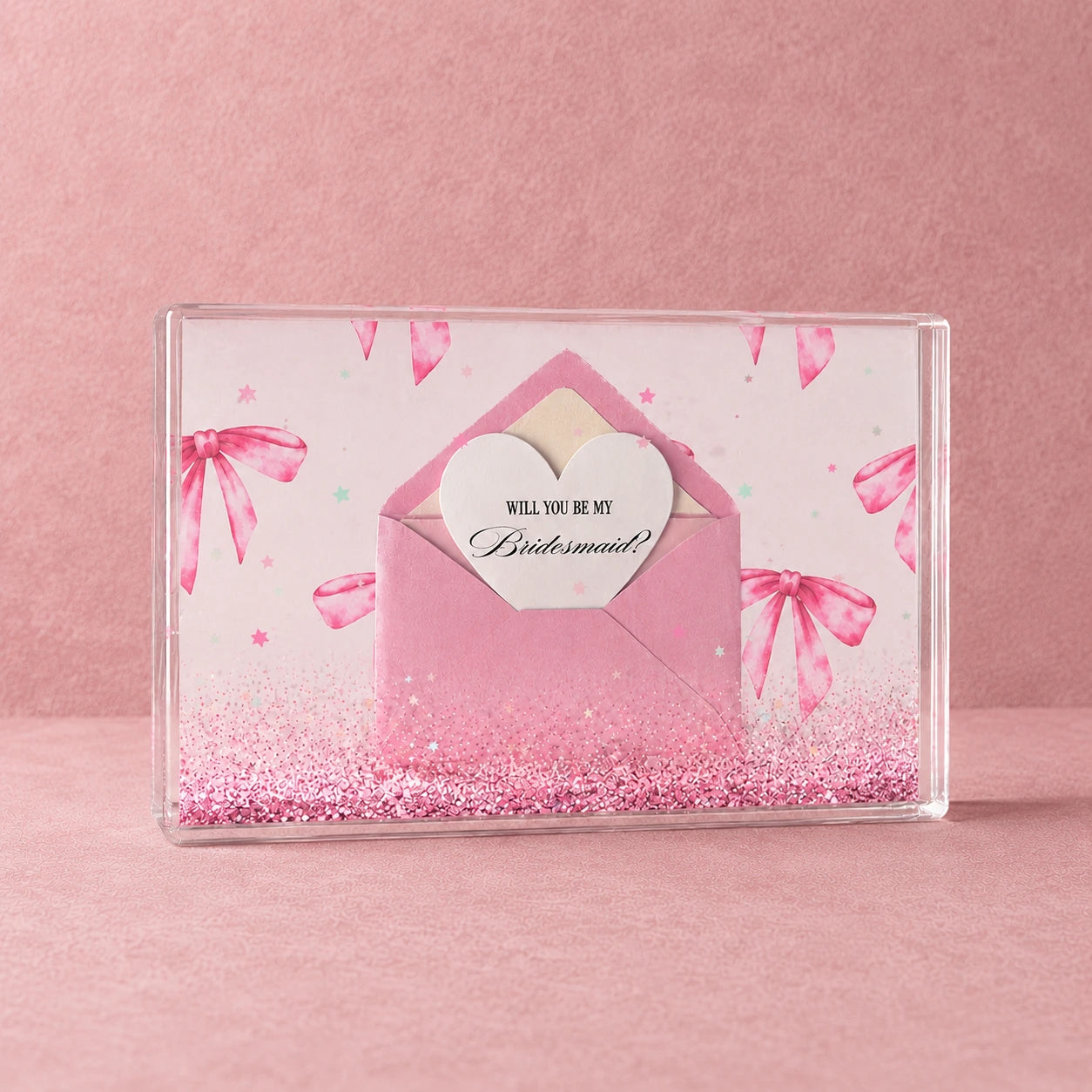 Bridesmaid proposal confetti block with pink envelope, heart card, glitter and star confetti on a textured pink background.