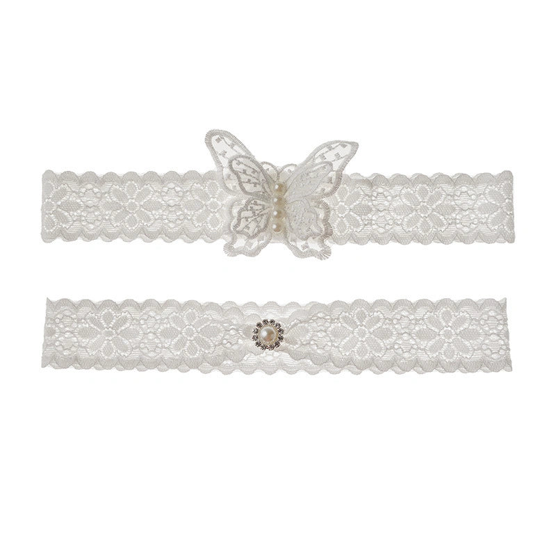 Two white lace garters with decorative elements on a white background