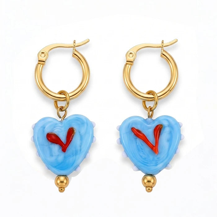 A pair of gold hoop earrings with light blue heart-shaped dangles featuring a red heart design and small gold beads at the bottom, shown on a plain white background.