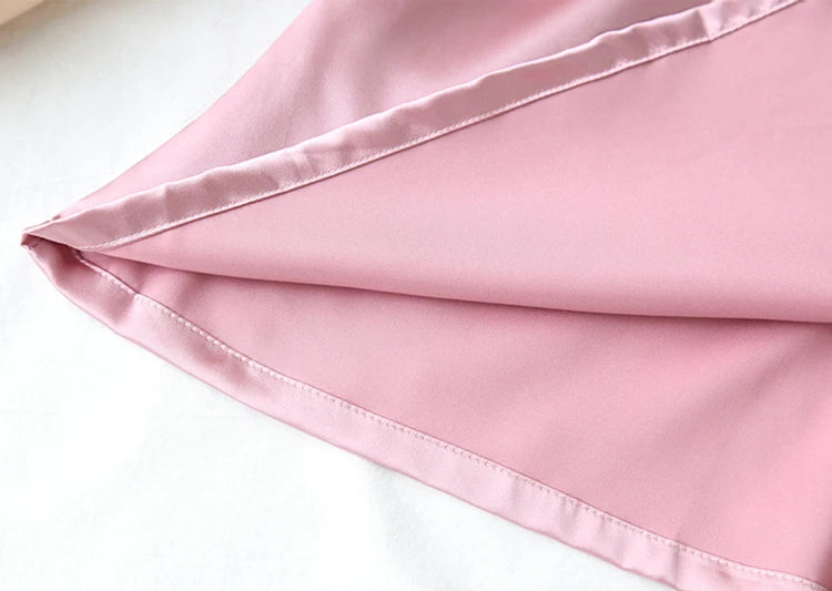 Close-up of pink satin fabric on a white background