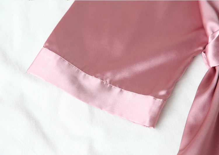 Close-up of a pink satin fabric with a bow on a white background