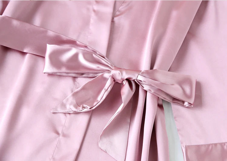 Close-up of a pink satin robe with a large bow.
