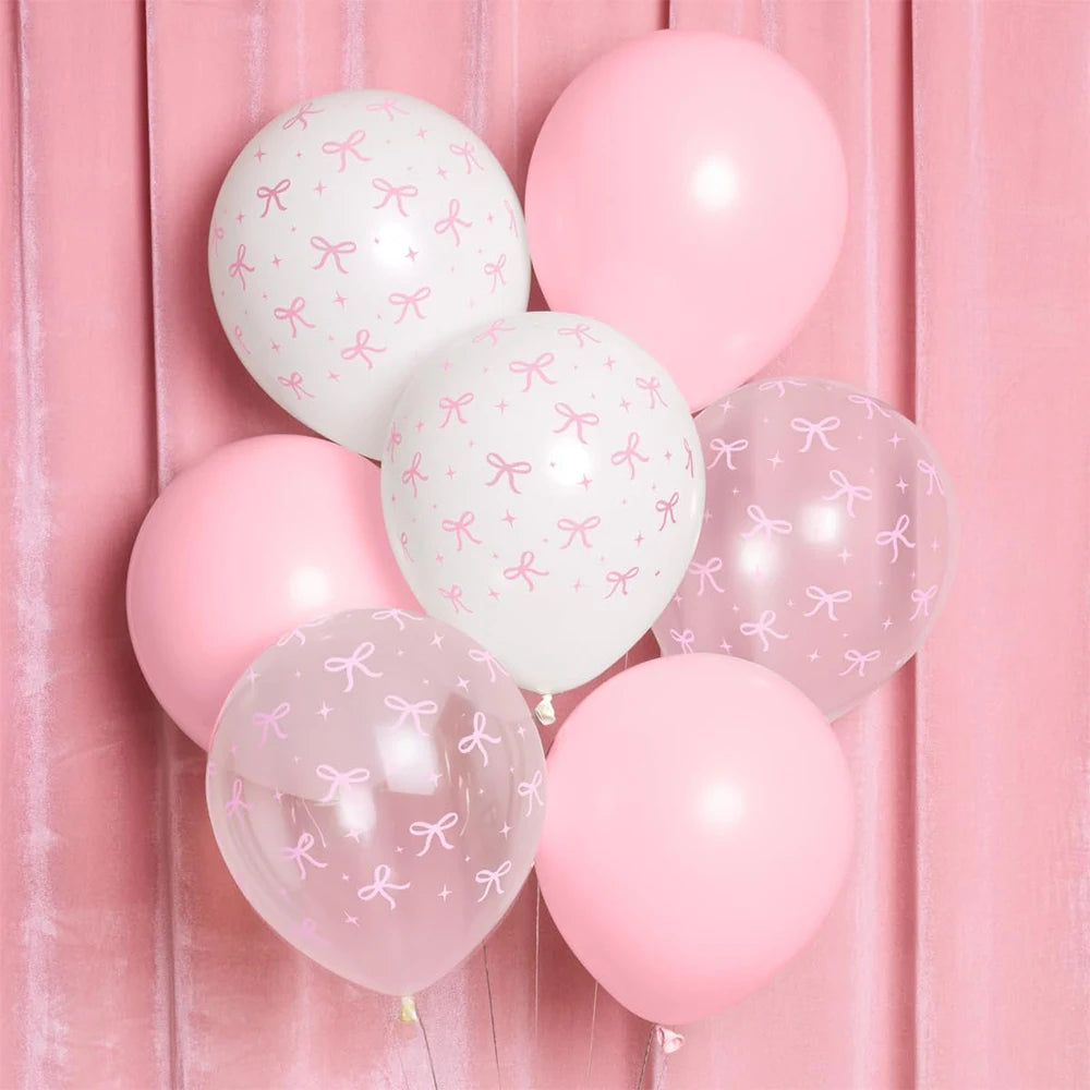Pink and white balloons with bow patterns against a pink background