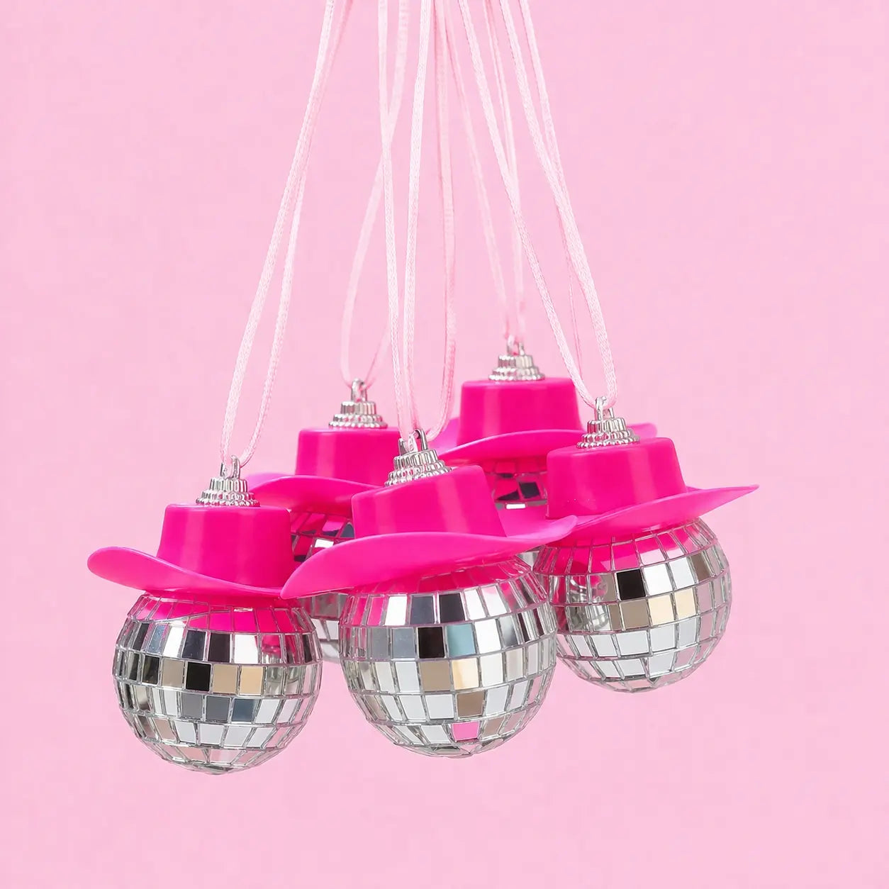 Pink disco ball hanging decorations on a pink background