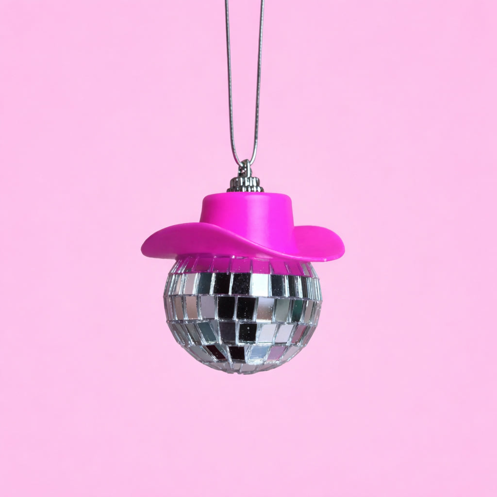 Hot pink disco cowgirl car mirror charm with a mini cowboy hat and mirrored disco ball on a soft pink background.