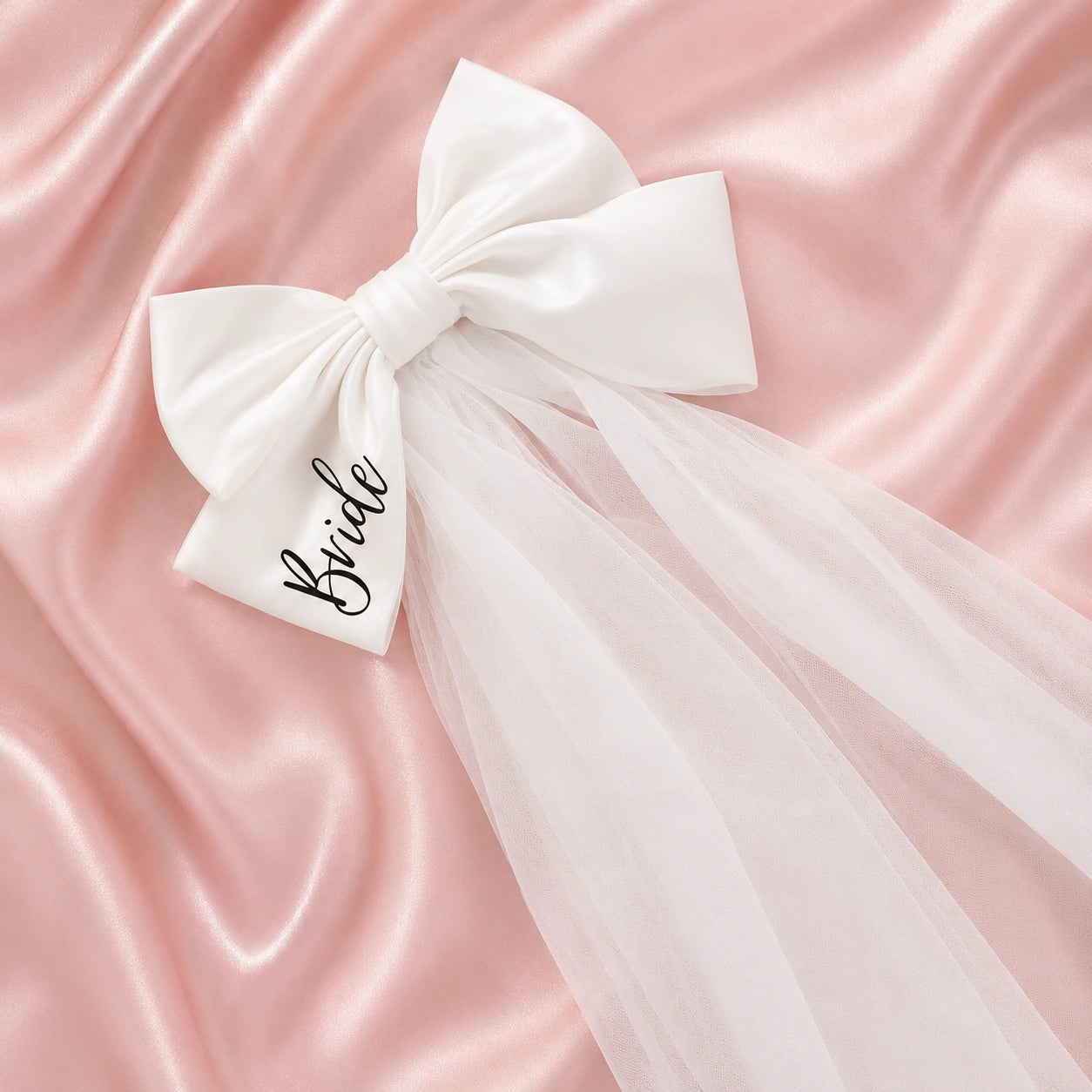 Large white bow with 'Bride' on a pink fabric background