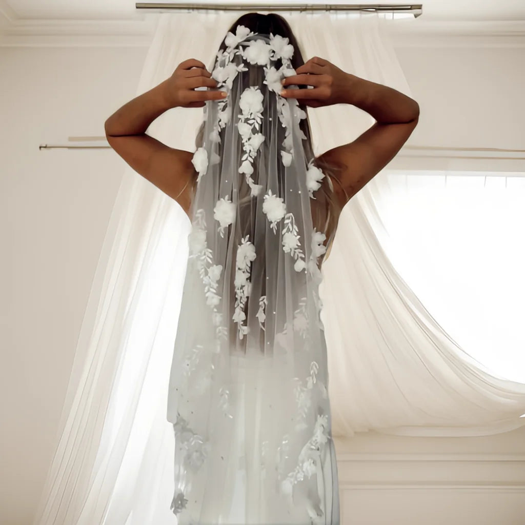 Bride wearing the Flora Pearl Bridal Veil from the back, showing floral appliqué, pearl-style details, and soft tulle.