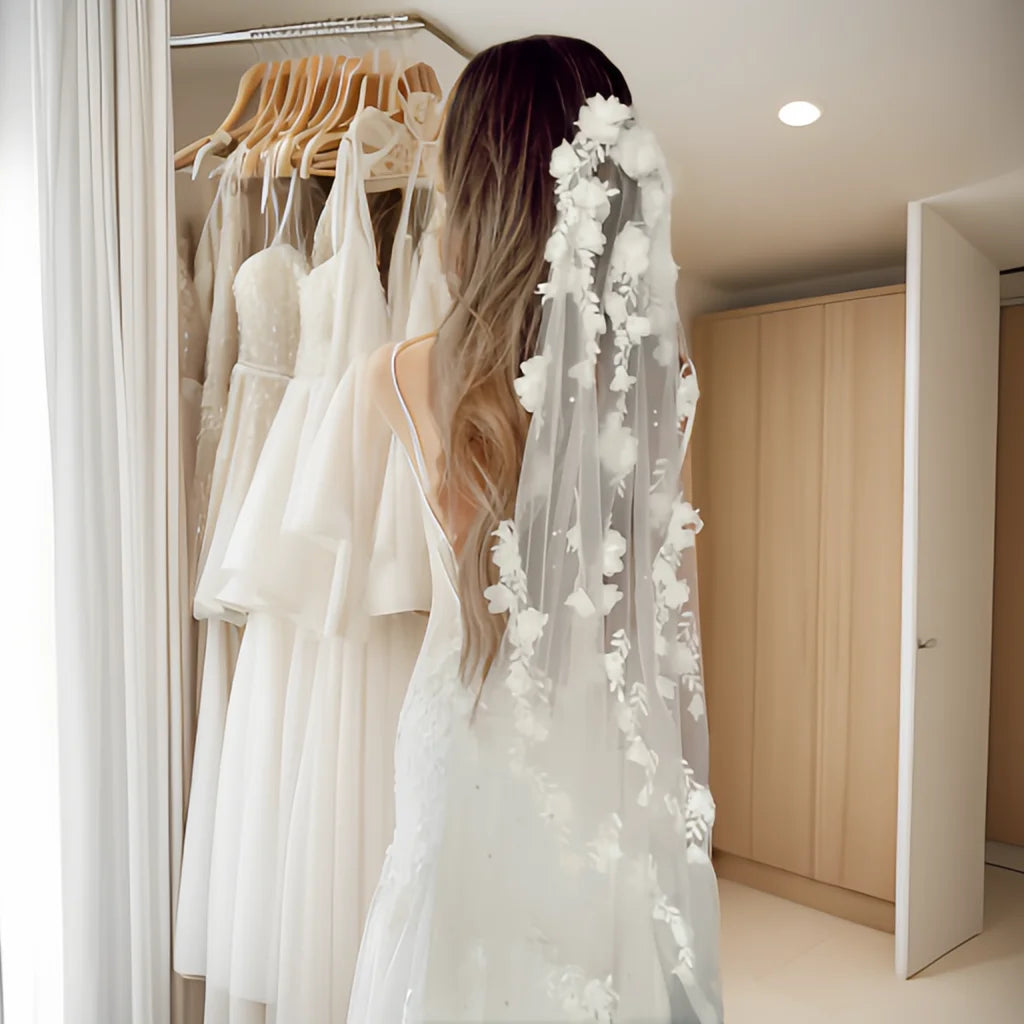 Bride wearing the Flora Pearl Bridal Veil from the back in a bridal boutique setting with soft floral details.
