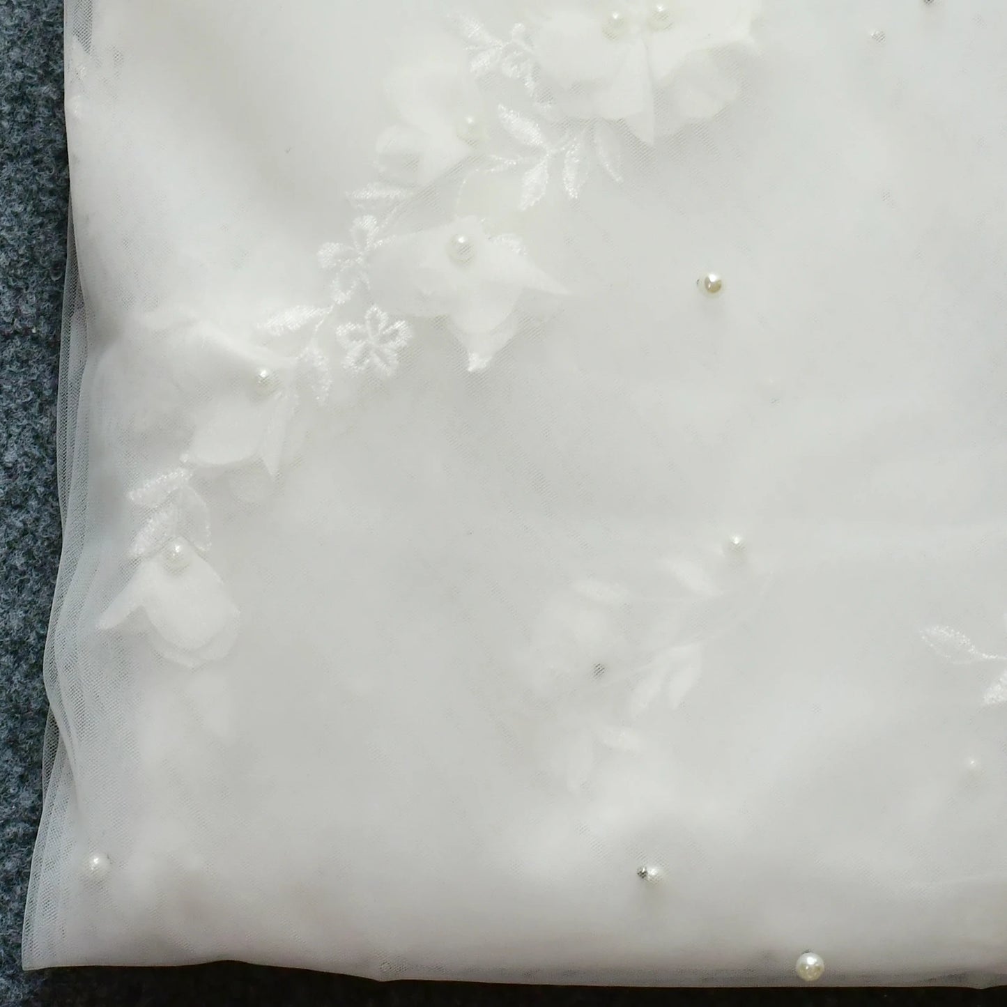 Close-up detail of pearl-style accents and floral appliqué on the Flora Pearl Bridal Veil.