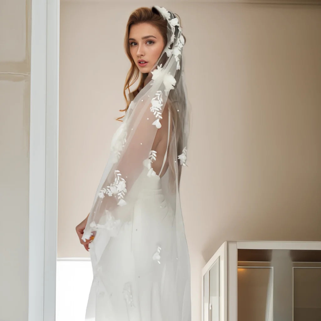 Side portrait of bride wearing the Flora Pearl Bridal Veil with soft floral tulle and pearl-style beading.