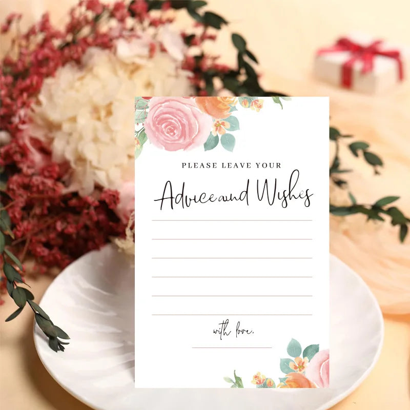 Note card with floral design on a table with flowers and a gift.