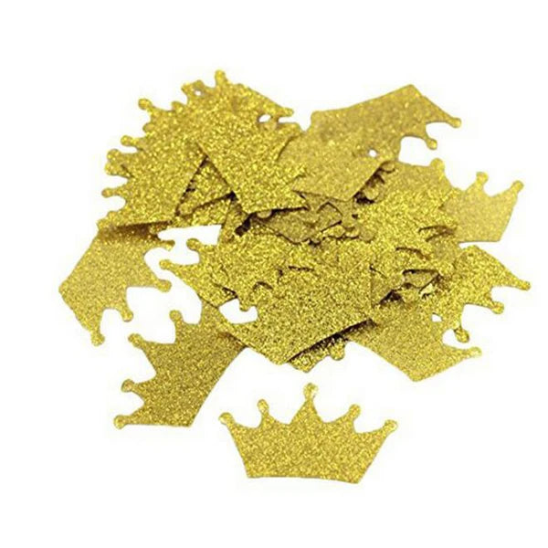 Gold glittery crown-shaped confetti pieces on a white background