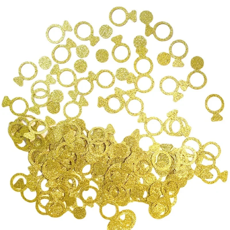Gold glittery ring-shaped confetti on a white background