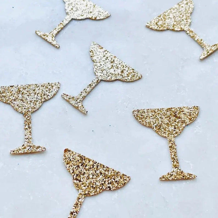 Gold glittery martini glass shapes on a light blue background