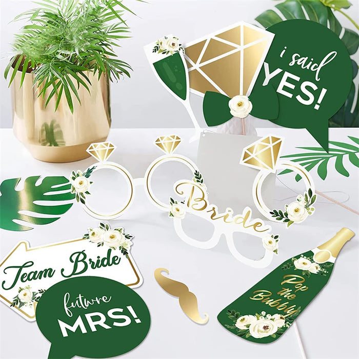 Bridal shower decorations including glasses, signs, and a plant on a white background