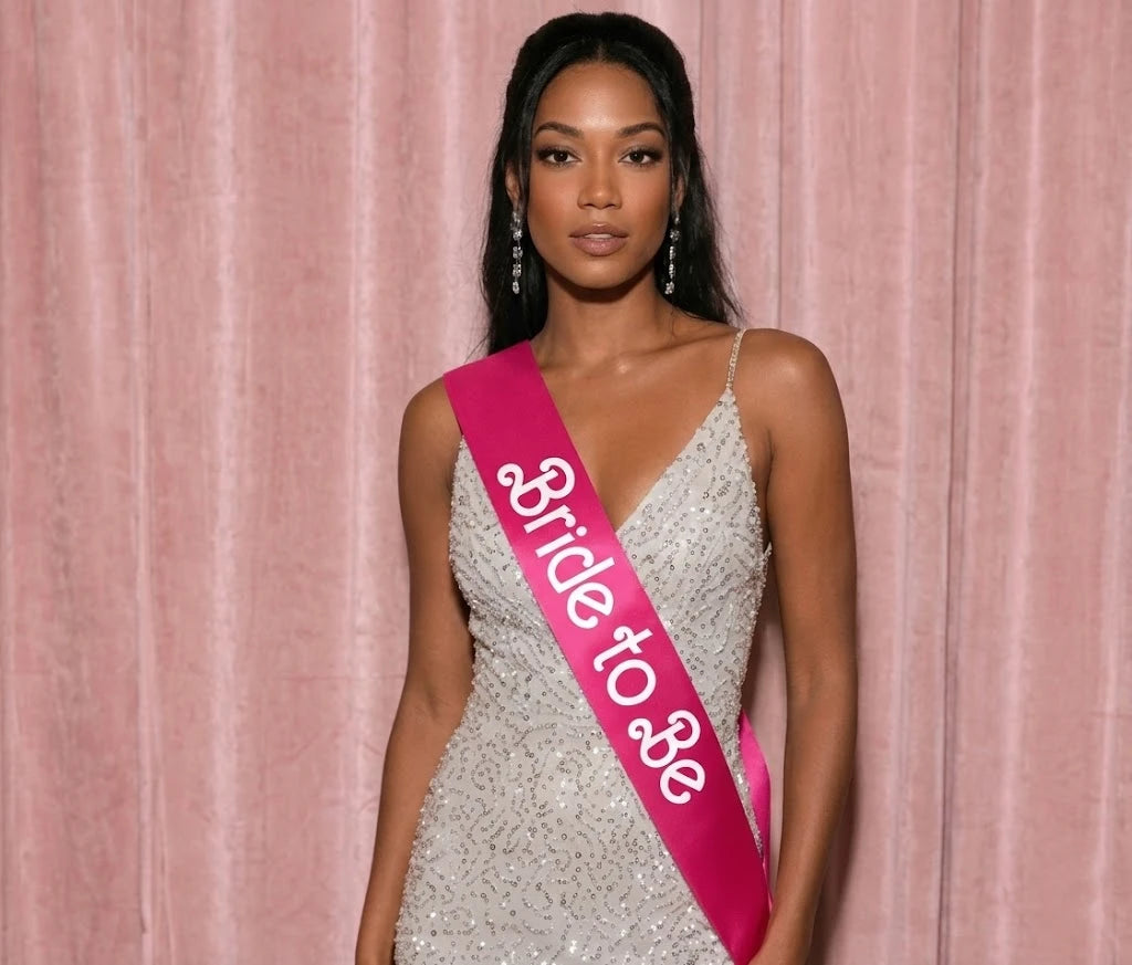 Woman wearing a 'Bride to Be' sash against a pink curtain background