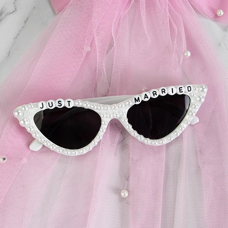 Sunglasses with 'Just Married' text on a pink tulle background