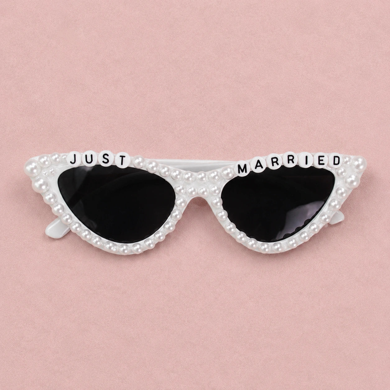 Sunglasses with 'Just Married' text on a pink background