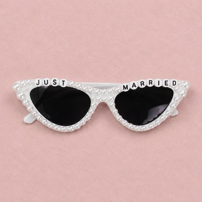 Sunglasses with 'Just Married' text on a pink background
