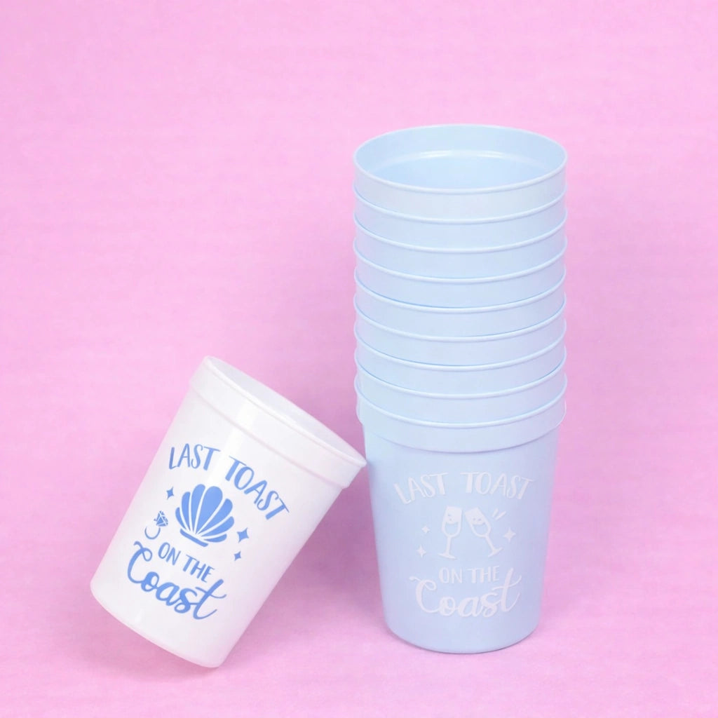 Stack of light blue cups with 'Last Toast on the Coast' text on a pink background