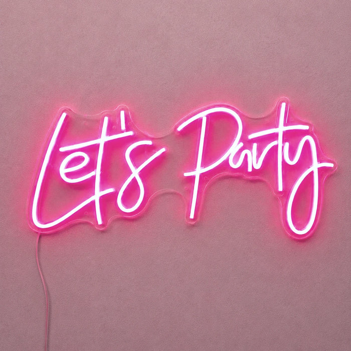 A pink neon sign spelling out 'Let's Party' in a glowing script font against a matching pink background.