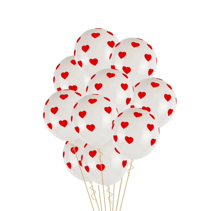 A cluster of white latex balloons printed with small red hearts, tied together with thin gold-colored strings against a plain white background.