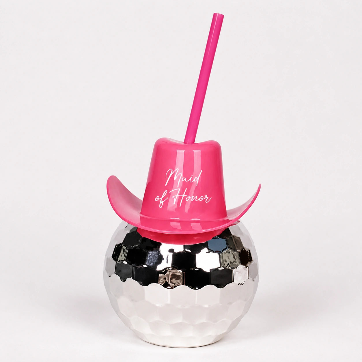 Pink cup with straw and 'Maid of Honor' text on a silver ball with rhinestones against a white background