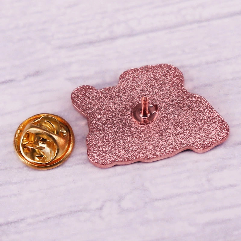 Back of rose gold lapel pin on a textured white surface