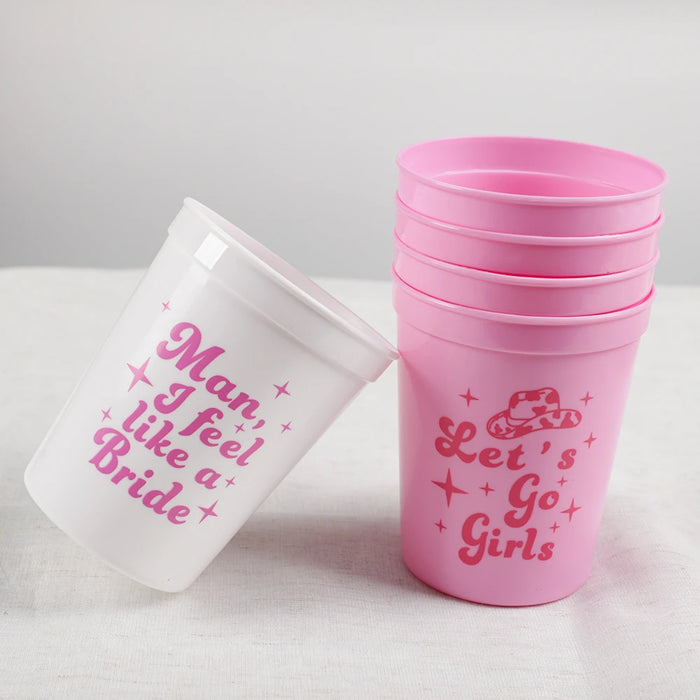 Pink and white cups with bachelorette-themed text on a light gray background